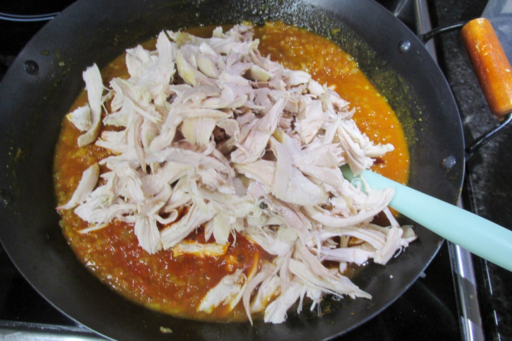 Add the shredded chicken to the pan and mix. 