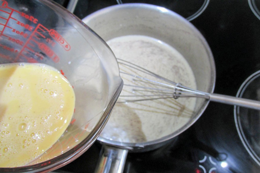 Slowly whisk the eggs into the remaining milk.
